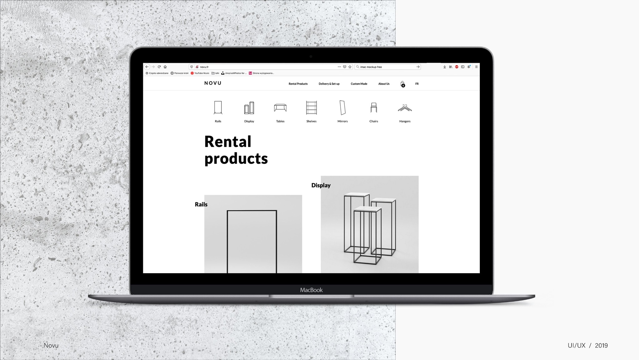 Ekran laptopa MacBook prezentuje stronę internetową Novu z ofertą produktów do wynajęcia: regały, ekspozytory, stoły, wieszaki. Minimalistyczny design, szara kolorystyka.