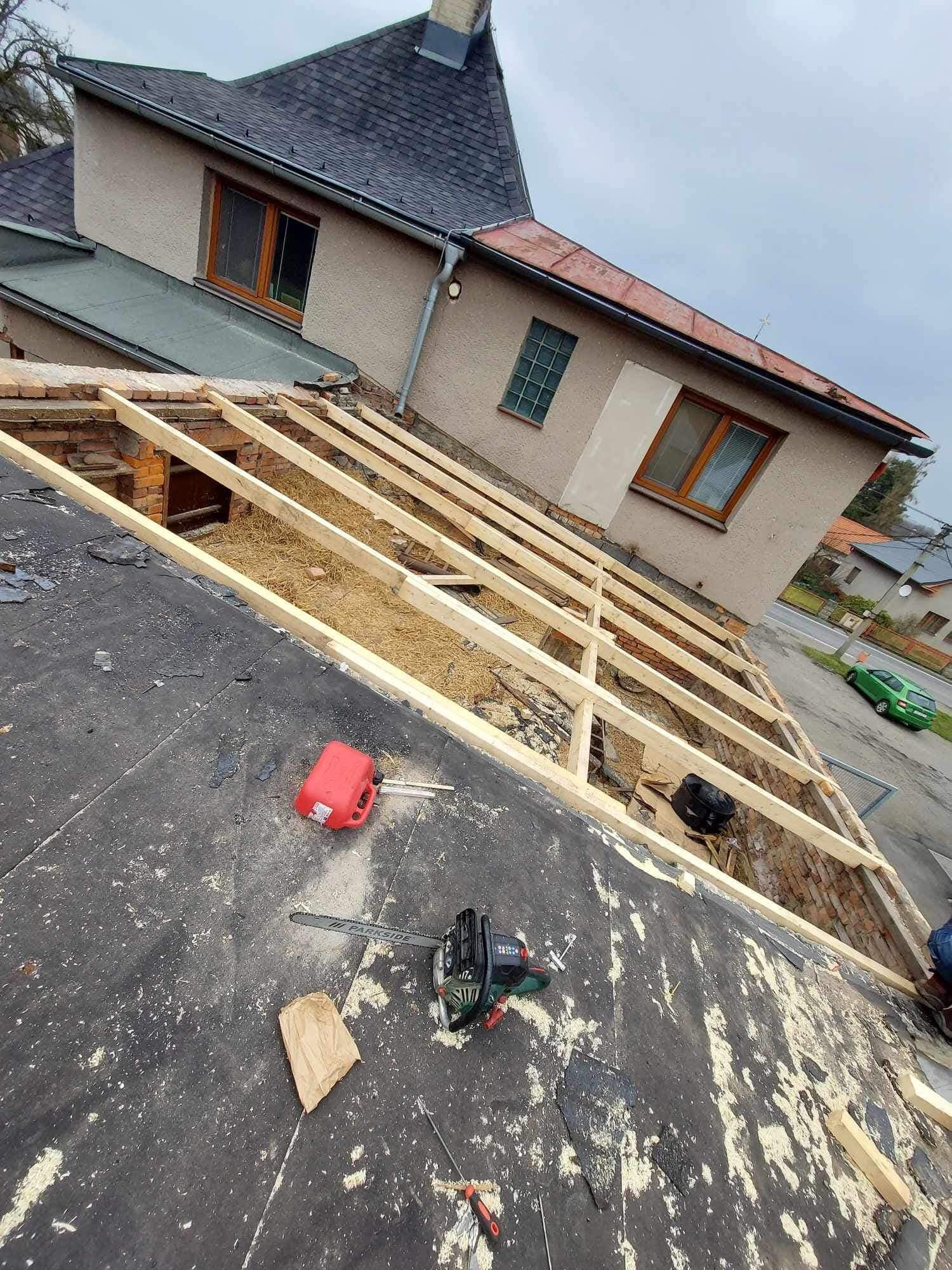 Demontaż starego dachu z widoczną konstrukcją więźby, resztki pokrycia na membranie, narzędzia (piła, kanister) i fragment budynku w tle. Ujęcie z góry.