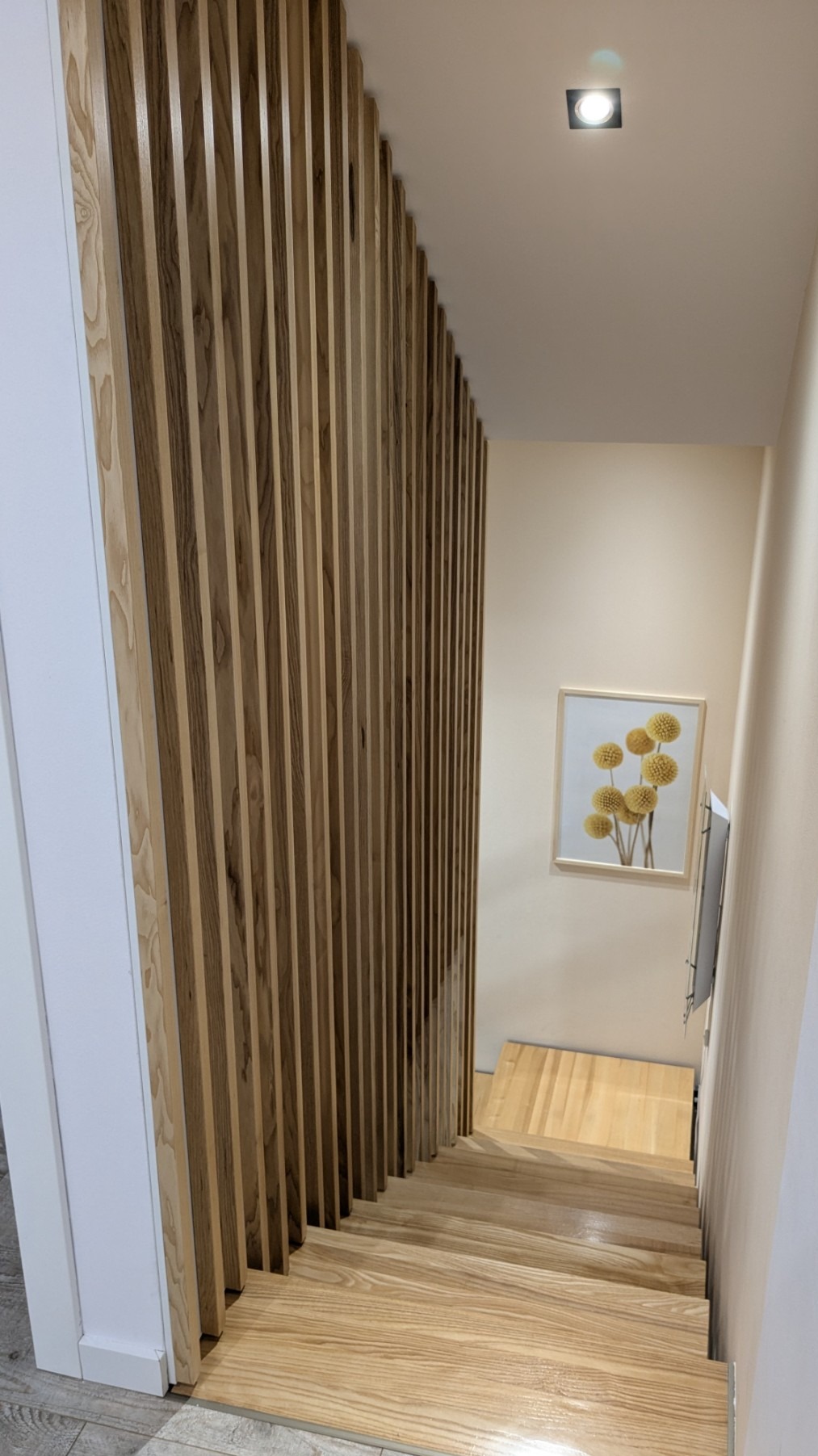 Ściana z lameli na klatce schodowej. Schody jesionowe