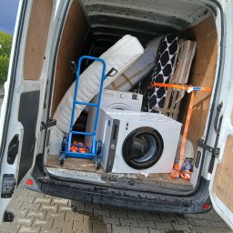 Bus Mrówka Trans podczas realizacji przeprowadzki w Szczecinie – załadowana paka z meblami i sprzętem, wszystkie rzeczy starannie zabezpieczone pasami transportowymi. Bezpieczny i profesjonalny transport to nasz standard.