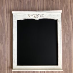 We made it Tomasz Białek - Rustykalna, biała rama lustra z dekoracyjnym ornamentem, zawieszona na ścianie z drewnianą okładziną. Czarne lustro. Styl vintage, bliski kadr.