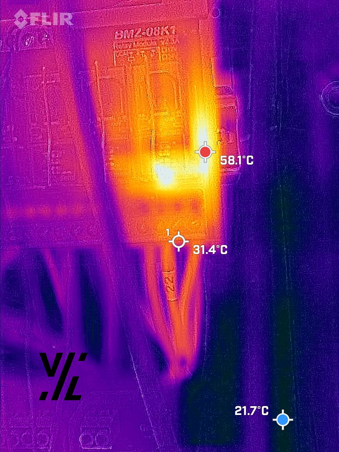 Obraz termowizyjny rozdzielnicy elektrycznej z zaznaczonymi punktami pomiaru temperatury, wskazującymi potencjalne przegrzewanie się elementów.