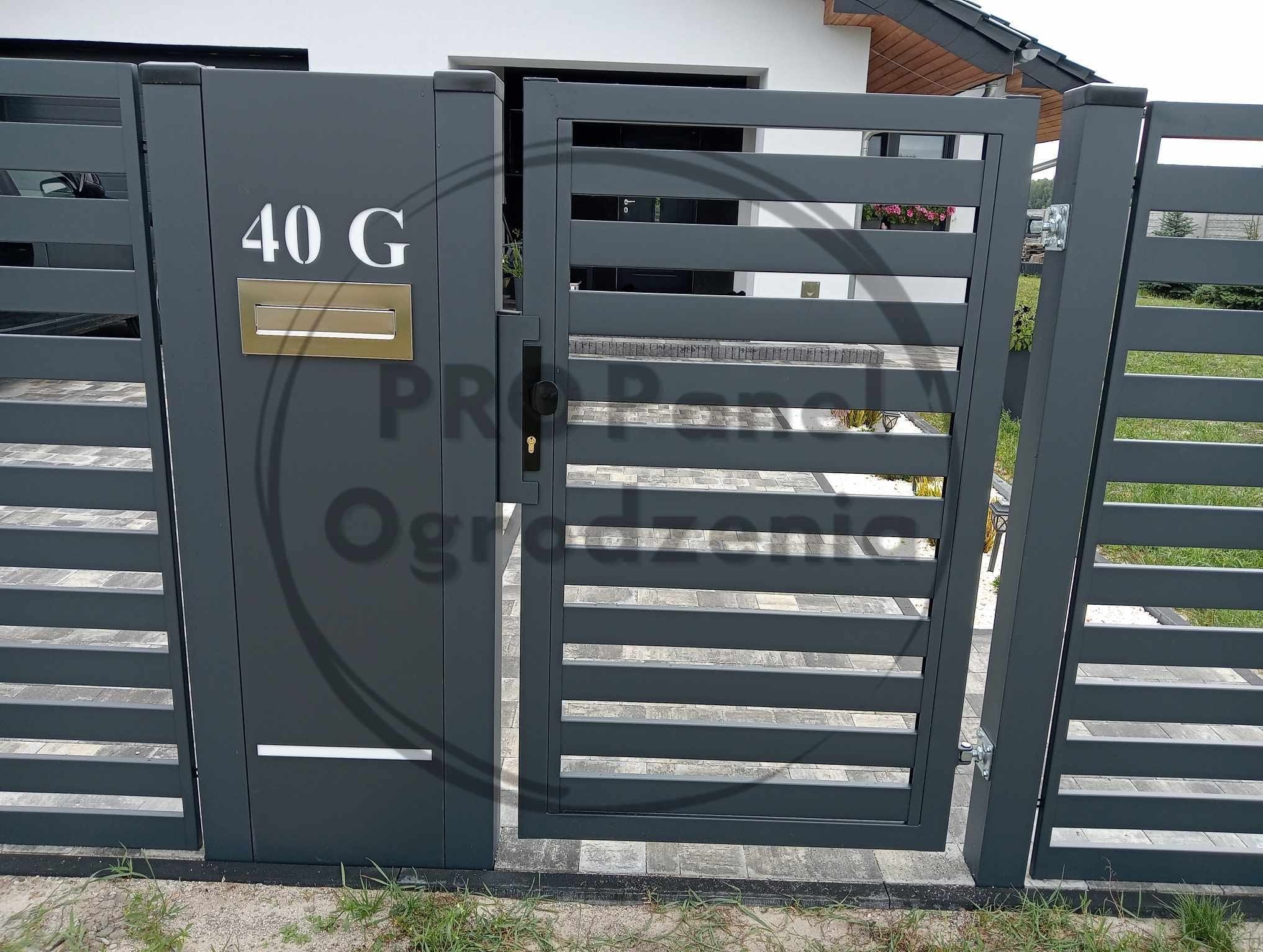 Nowoczesna, grafitowa brama z numerem domu '40 G' i złotą skrzynką na listy, z poziomymi panelami, otwierająca się na posesję z kostki brukowej.