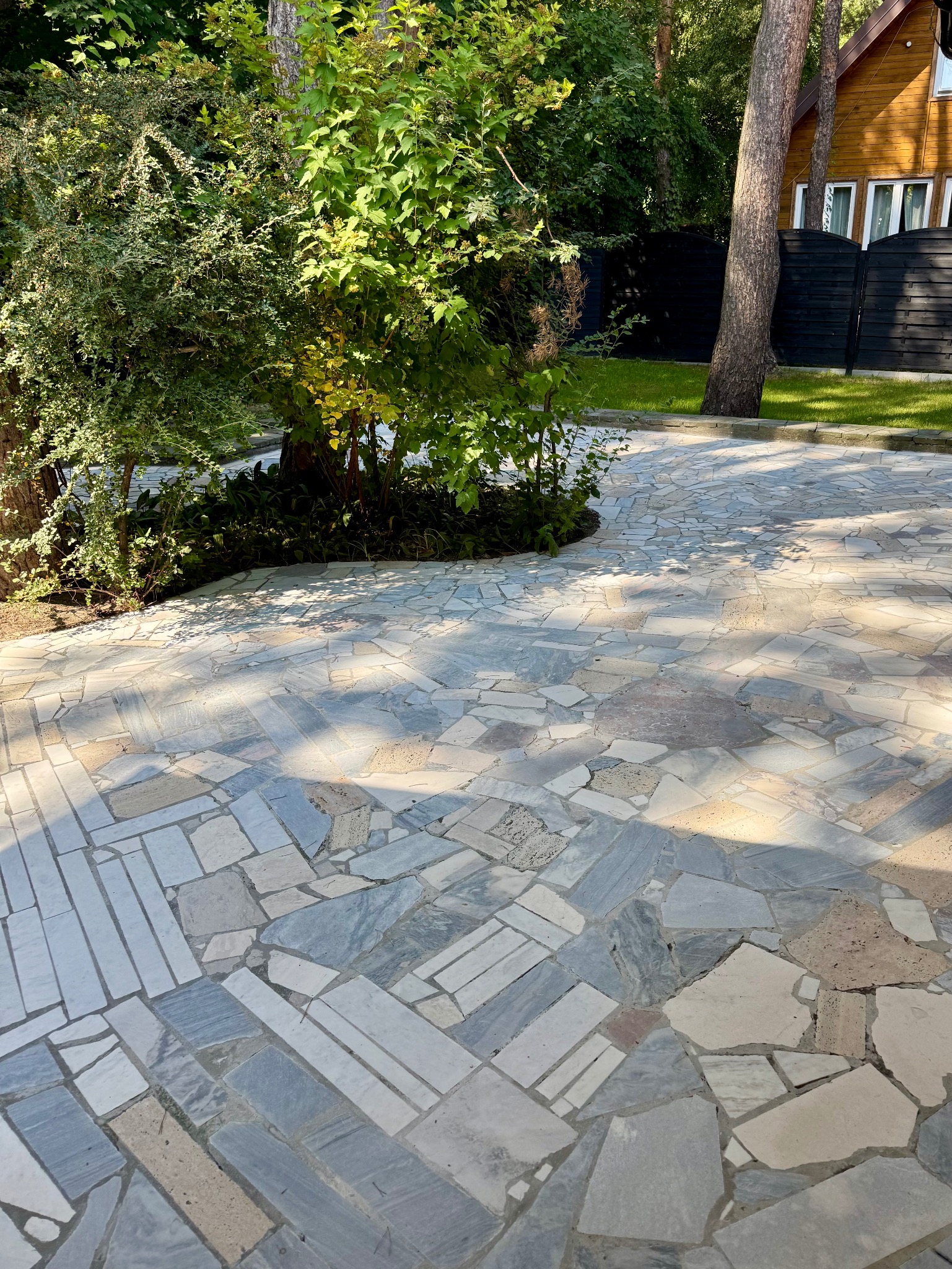 Odnowiony taras wykonany z tzw. dzikówki czyli płytek marmurowych w nieregularnych kaształtach.