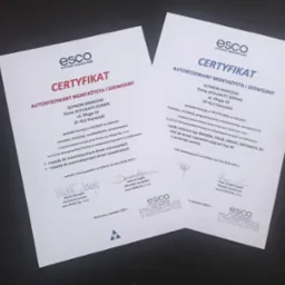 Dwa certyfikaty firmy ESCO dla Accugate Serwis, potwierdzające uprawnienia do montażu i serwisu automatyki do drzwi oraz okien. Dokumenty z podpisami i datą ważności.