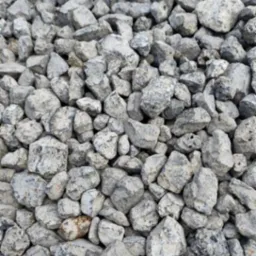 Szary, drobny żwir o nieregularnych kształtach, wypełniający całą przestrzeń kadru. Widoczne detale faktury kamieni.