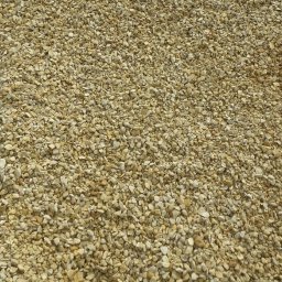 Rojber-trans Tomasz Borowski - Jasny żwir o nieregularnych kształtach, drobna frakcja, równomiernie rozłożony, widok z góry, naturalne światło, delikatne cienie.