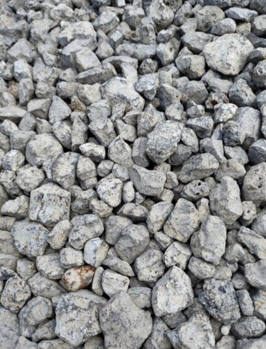 Szary, drobny żwir o nieregularnych kształtach, wypełniający całą przestrzeń kadru. Widoczne detale faktury kamieni.