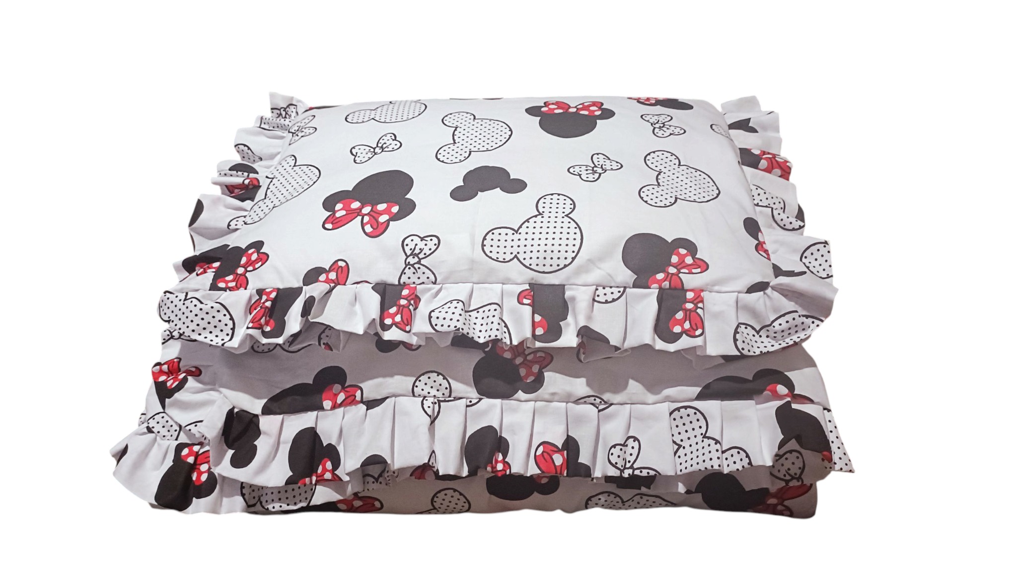 Dwa białe, kwadratowe poduszki z falbankami i wzorem Myszki Minnie, ułożone jedna na drugiej, na białym tle. Widoczne detale wzoru: kokardy, głowy Myszki Miki.