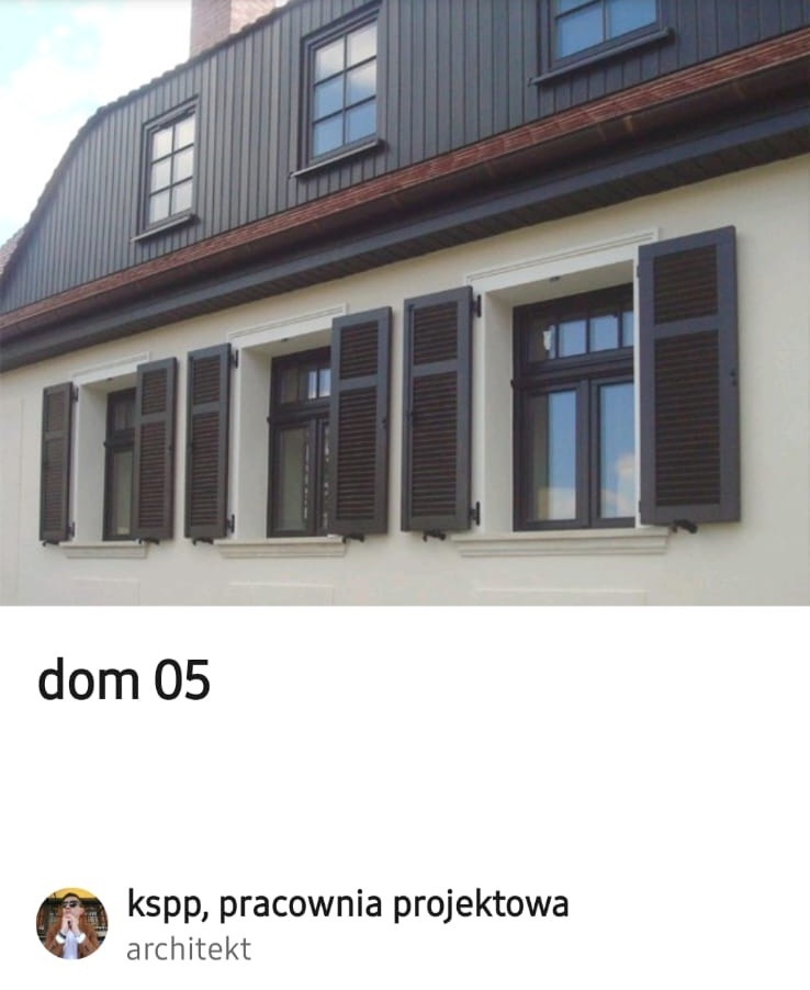 Elewacja domu z oknami i brązowymi okiennicami. Część okiennic jest otwarta. Widoczna drewniana obudowa poddasza w kolorze ciemnobrązowym.