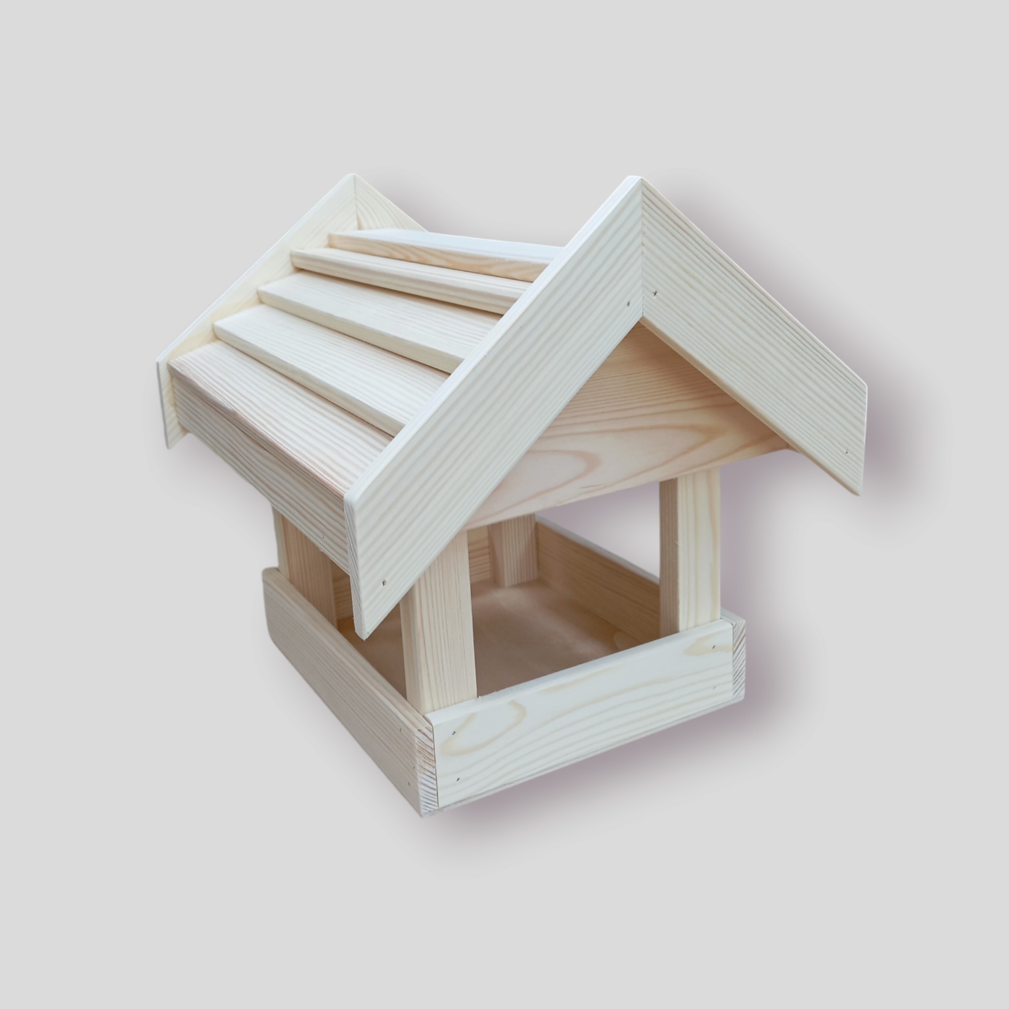 Drewniany karmnik dla ptaków z jasnego drewna, wykonany w Makowie Podhalańskim. Solidna konstrukcja z trójstopniowym dachem, idealny dla miłośników natury.