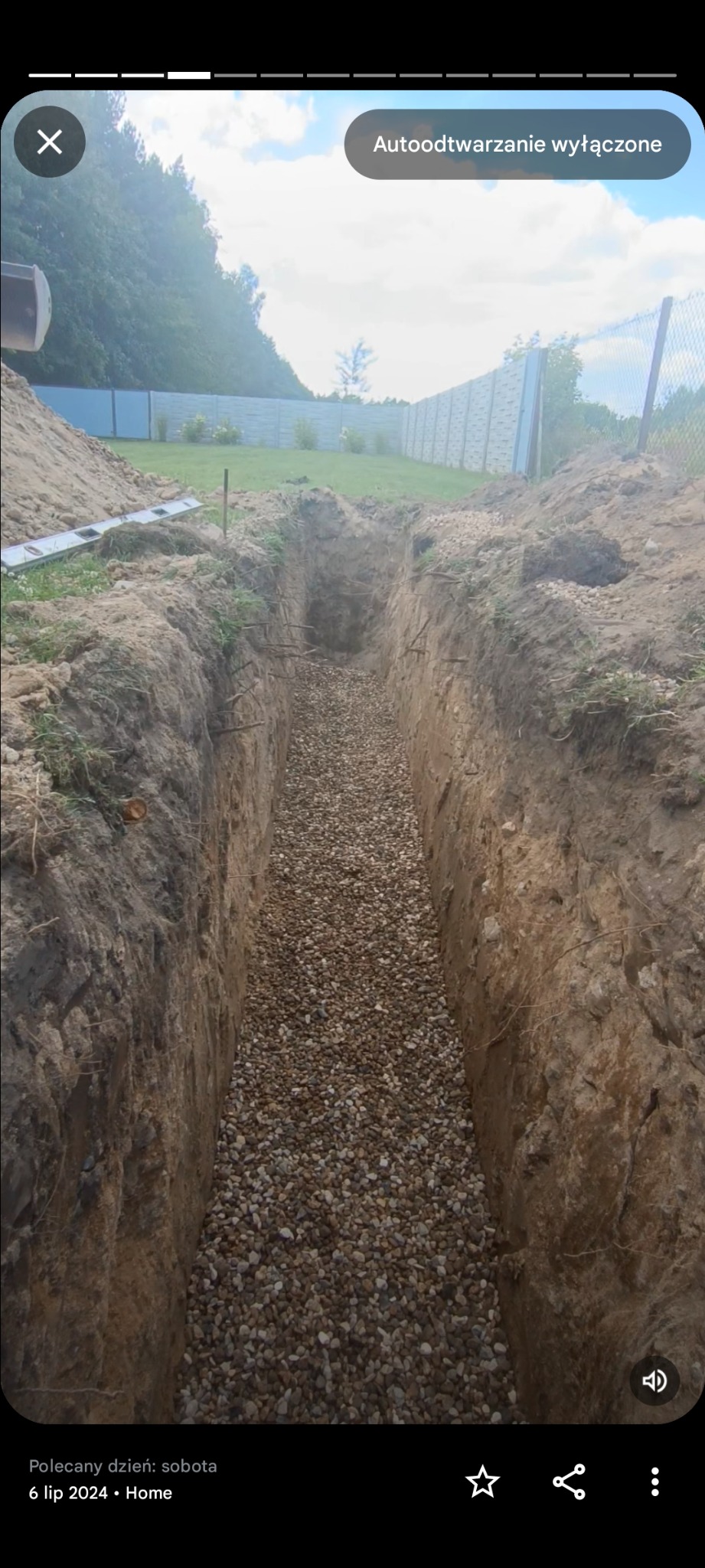 Wykopany rów wypełniony żwirem na posesji z ogrodzeniem panelowym. Widoczne ślady po wykoparce i przygotowania do dalszych prac instalacyjnych.