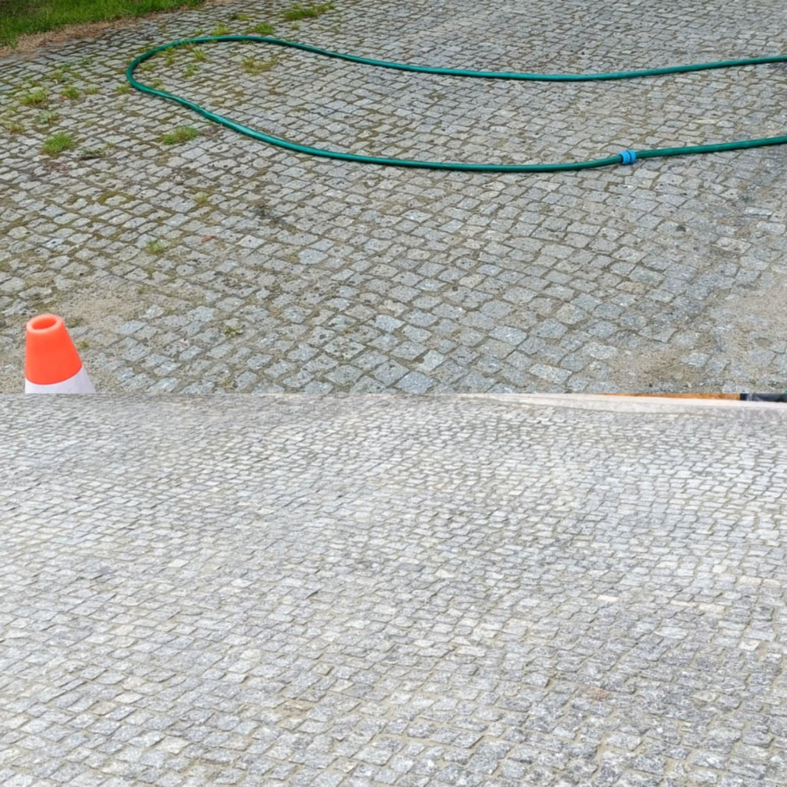 Szara kostka brukowa z zielonym wężem ogrodowym i pomarańczowym pachołkiem. Część kostki jest czysta, co sugeruje etap pracy lub obszar po czyszczeniu.