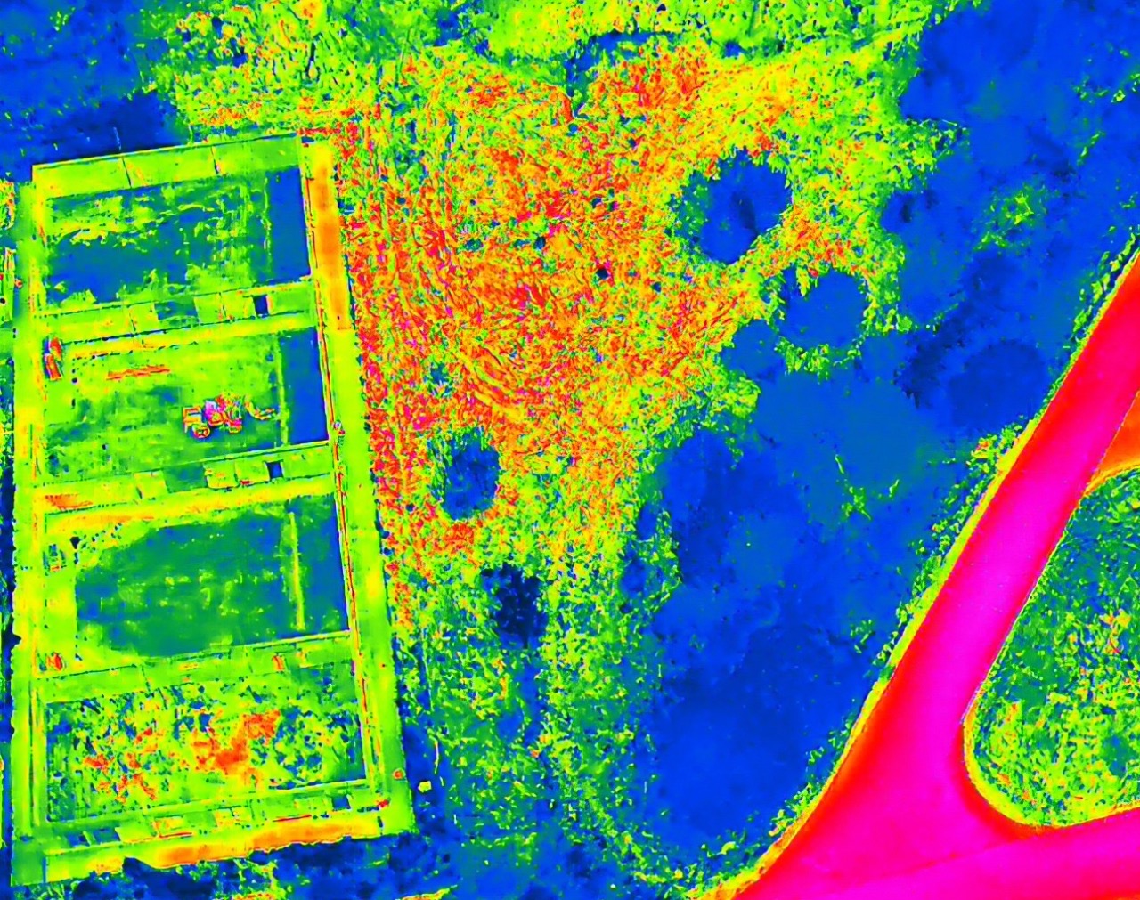 Termowizja fundamentów budynku w trakcie budowy, widok z góry. Analiza temperatury gruntu i konstrukcji. Wyraźne różnice temperatur w różnych obszarach.