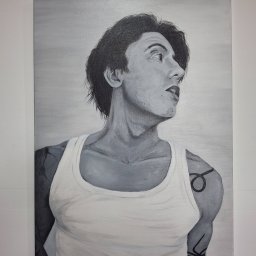 Piotr Wolski - Czarno-biały portret mężczyzny z tatuażami, namalowany na płótnie. Widoczny z profilu, ubrany w biały podkoszulek, z widocznymi detalami tatuaży na ramionach.