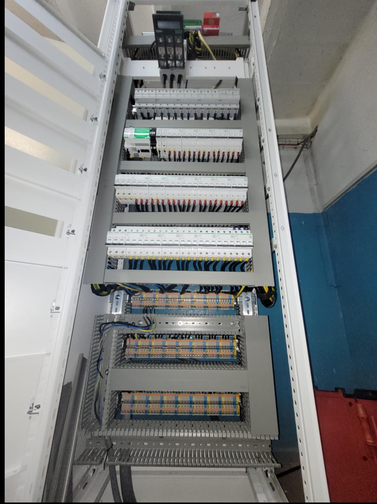 Rozdzielnica elektryczna z zabezpieczeniami i okablowaniem w szafie, widok z góry. Usługi elektryczne w Czarne Małe.