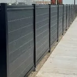 Nowoczesne, grafitowe ogrodzenie metalowe z poziomych paneli, oddzielające posesję od chodnika. Minimalistyczny design, regularne linie, równomierne oświetlenie.