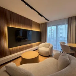 salon - zabudowa ściany salonowej z lameli, szafka rtv w delikatnych odcieniu beżu - tutaj kaszmir