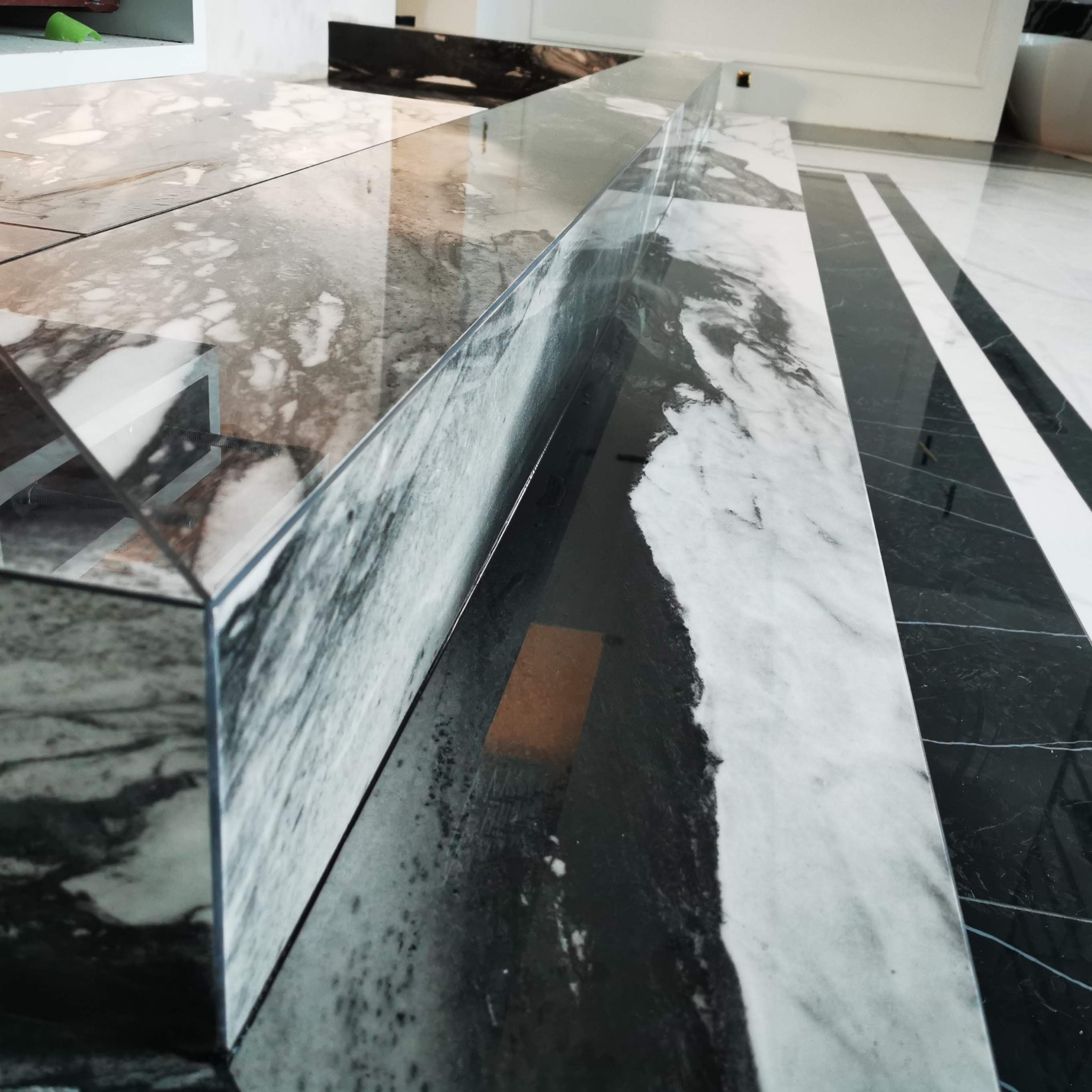 Marmurowe schody z czarno-białym wzorem żyłkowania, wykonane z precyzją i dbałością o detale, podkreślają elegancję wnętrza. Widoczne łączenia płyt.