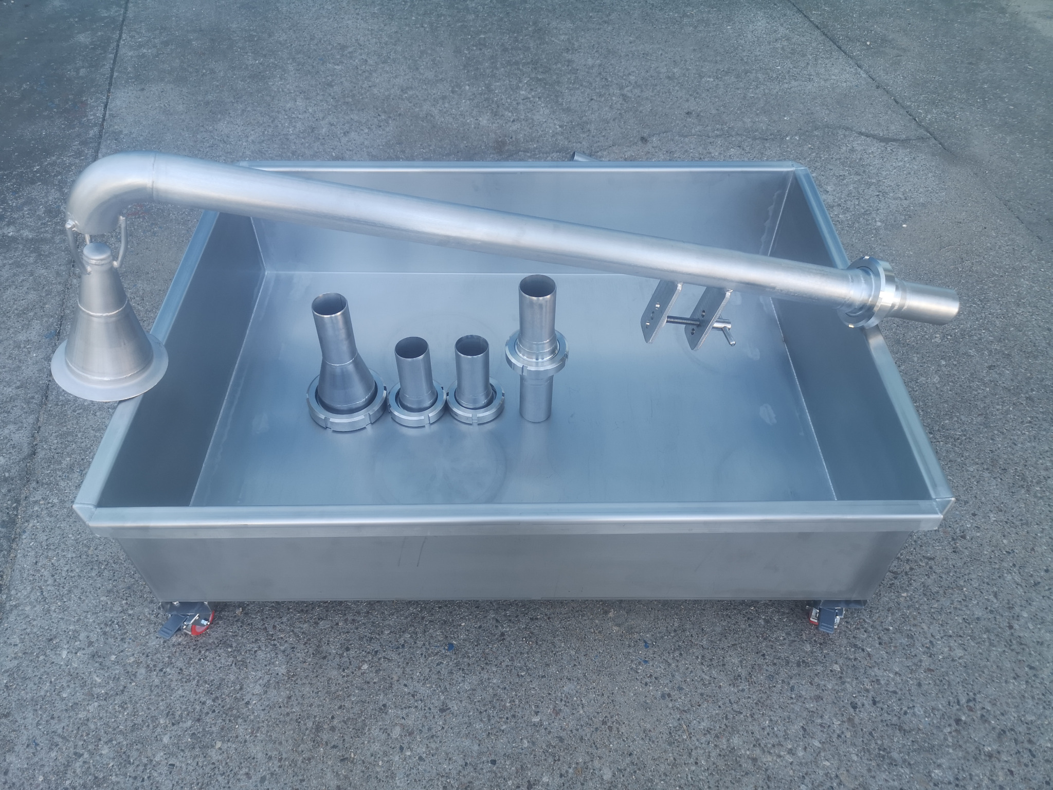 Metalowa wanna na kółkach z elementami rur i złączek w środku. Detale obróbki metalu. Produkcja w Puławach.