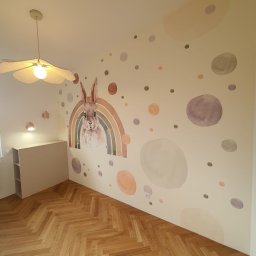 ABIKS WNĘTRZA - Pokój dziecięcy po malowaniu ścian: pastelowe kropki i królik z tęczą. Parkiet w jodełkę, lampa w kształcie kwiatu. Jasne, przytulne wnętrze.