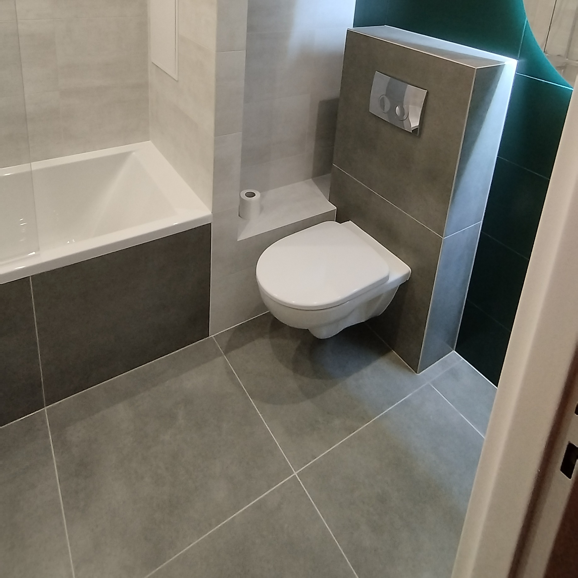 Nowoczesna łazienka po remoncie w Drohiczynie: szara glazura, podwieszana toaleta i zabudowana wanna. Minimalistyczny design z akcentem na funkcjonalność.