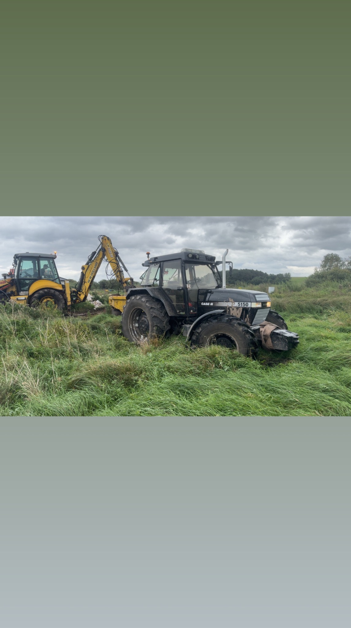 Dwa traktory na zarośniętym polu. Jeden czarny, drugi żółty z koparką. Praca w terenie, sprzęt budowlany, zachmurzone niebo. Maszyny rolnicze w akcji.