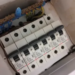 Rozdzielnia elektryczna z zamontowanymi bezpiecznikami Legrand B16 i B20, widoczne przewody i szyny zbiorcze. Instalacja w trakcie prac.