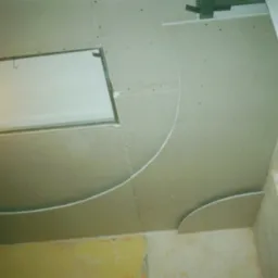 Sufit podwieszany z płyt gipsowo-kartonowych z elementami dekoracyjnymi w kształcie łuków, widoczne łączenia płyt i konstrukcja nośna.