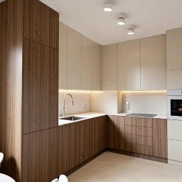 SZAJBA SPÓŁKA Z OGRANICZONĄ ODPOWIEDZIALNOŚCIĄ - Nowoczesna kuchnia z drewnianymi i beżowymi frontami, oświetleniem LED podszafkowym i białym piekarnikiem. Minimalistyczny design z elementami drewna.