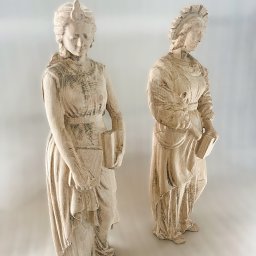 LAMDO SPÓŁKA Z OGRANICZONĄ ODPOWIEDZIALNOŚCIĄ - Dwie figury kobiece z książkami, wykonane metodą druku 3D. Widoczna struktura warstw, jasne drewno, delikatne detale i oświetlenie podkreślają trójwymiarowość.