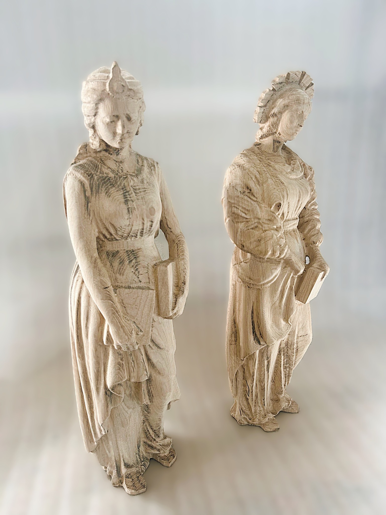 Dwie figury kobiece z książkami, wykonane metodą druku 3D. Widoczna struktura warstw, jasne drewno, delikatne detale i oświetlenie podkreślają trójwymiarowość.