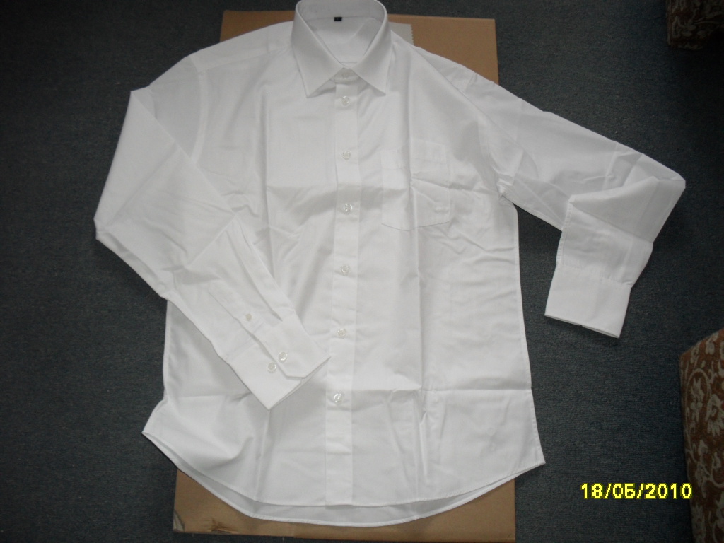 Rozłożona, biała, męska koszula z długim rękawem, widoczna na kartonowym podłożu, z datą 18/05/2010 w prawym dolnym rogu.