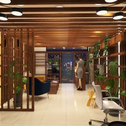 Renata Urban Projekty na 4 kąty - Eklektyczne wnętrze salonu z drewnianymi elementami, roślinami doniczkowymi i widokiem na nocne miasto. Kobieta w szarej sukience stoi przy recepcji.