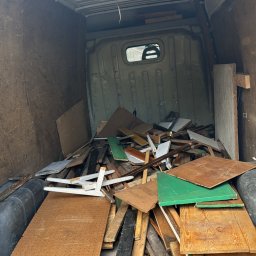 Patryk Kania - Wnętrze furgonetki wypełnionej gruzem i odpadami drewnianymi po remoncie, widoczne różne kolory i faktury materiałów.