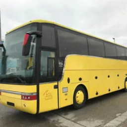 Żółty autokar turystyczny marki Astron 916, z widocznym logo firmy G.T.I. z 1986 roku, zaparkowany na zewnątrz. Widoczna karoseria i okna.