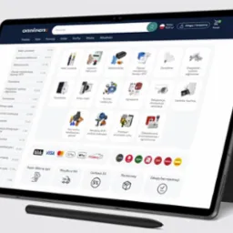 Tablet z otwartą stroną internetową sklepu Onninen, prezentujący asortyment: kable, elektrotechnikę i inne. Widoczny rysik. Minimalistyczne tło.