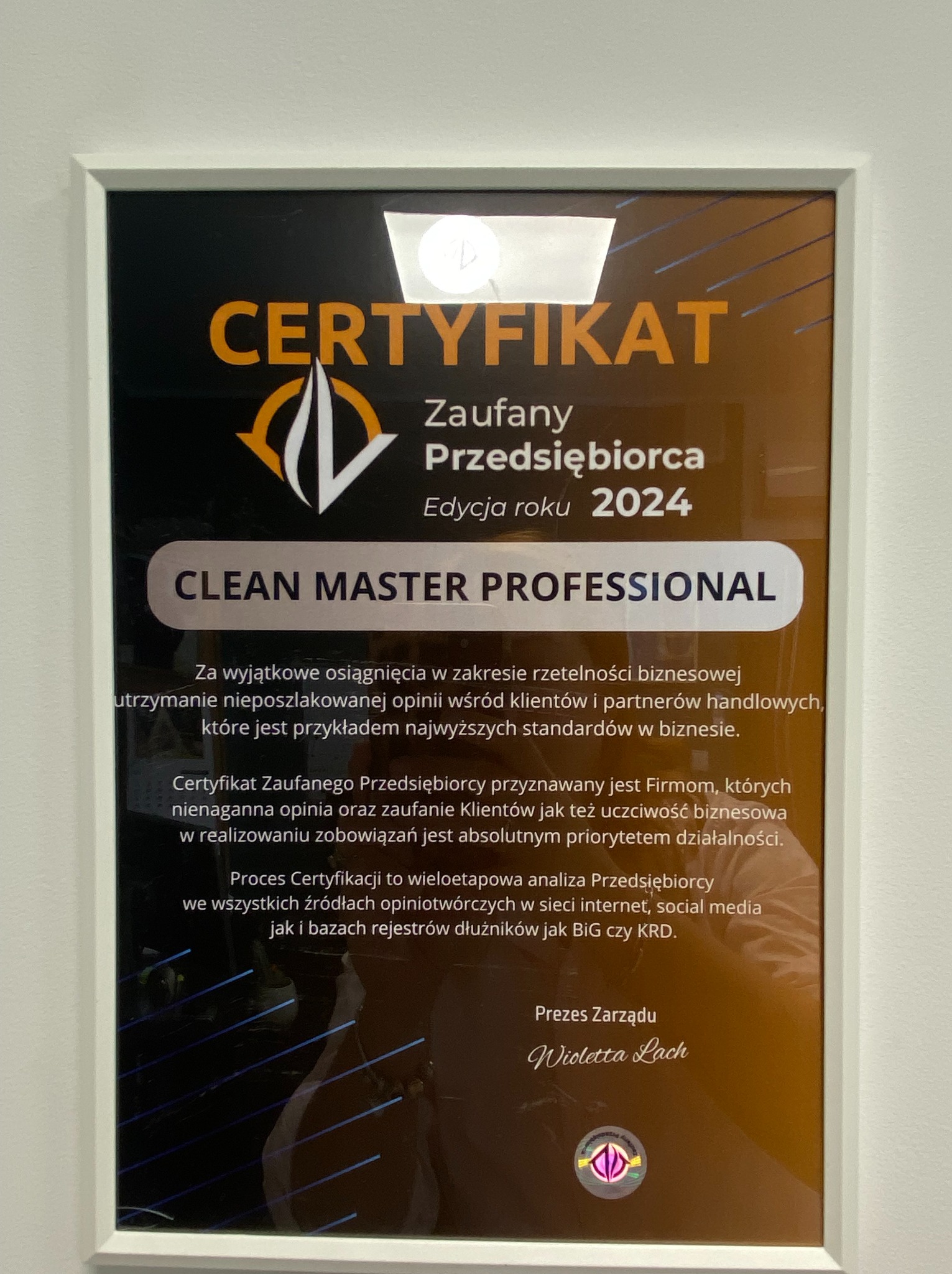 Oprawiony certyfikat 'Zaufany Przedsiębiorca 2024' dla Clean Master Professional. Dokument z tekstem i logo, w białej ramce, zawieszony na jasnej ścianie.