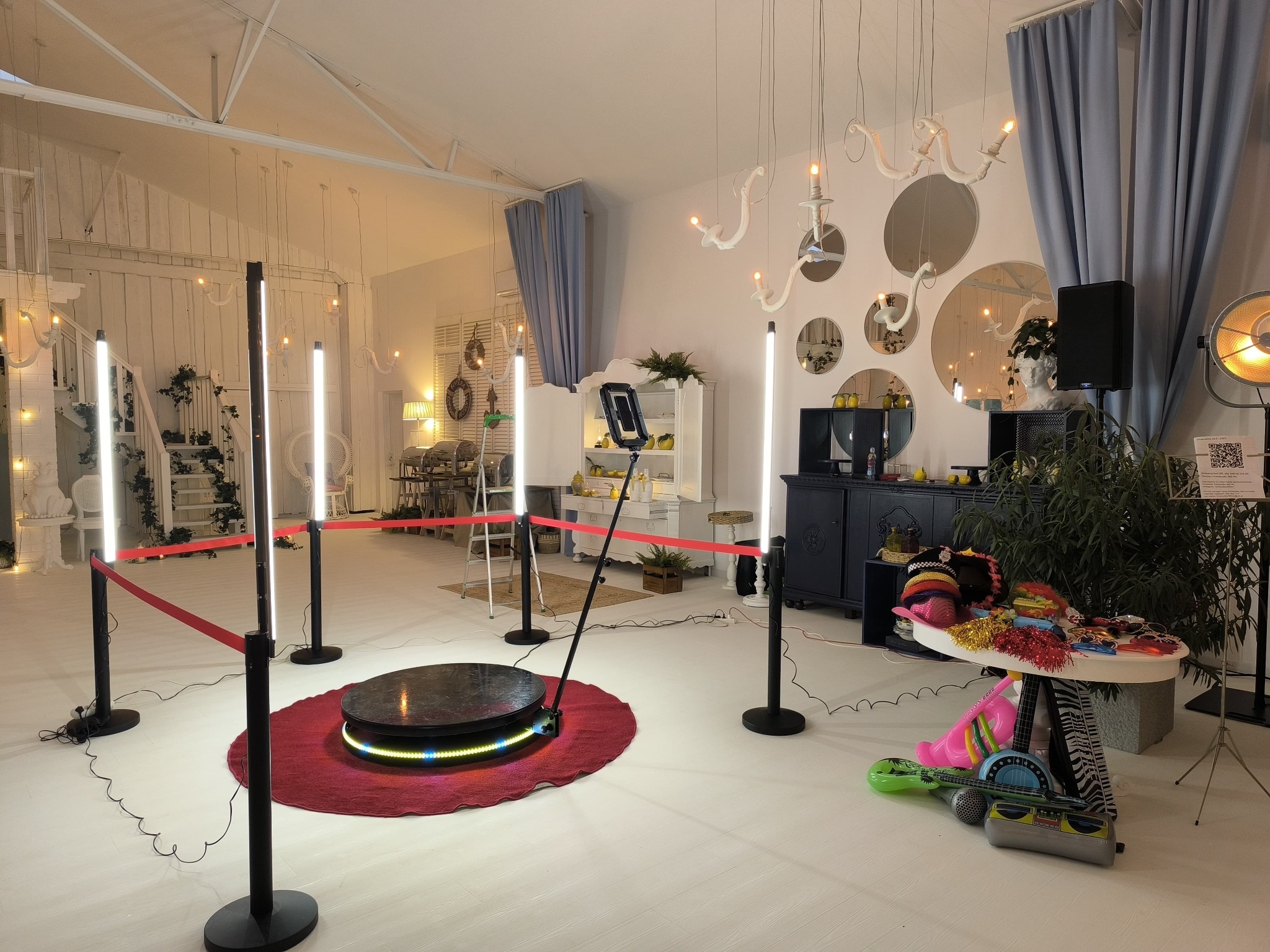 Wnętrze studia z platformą obrotową 360, oświetleniem LED i rekwizytami. Dekoracje w stylu glamour z lustrami i zasłonami. Idealne na imprezy i eventy.