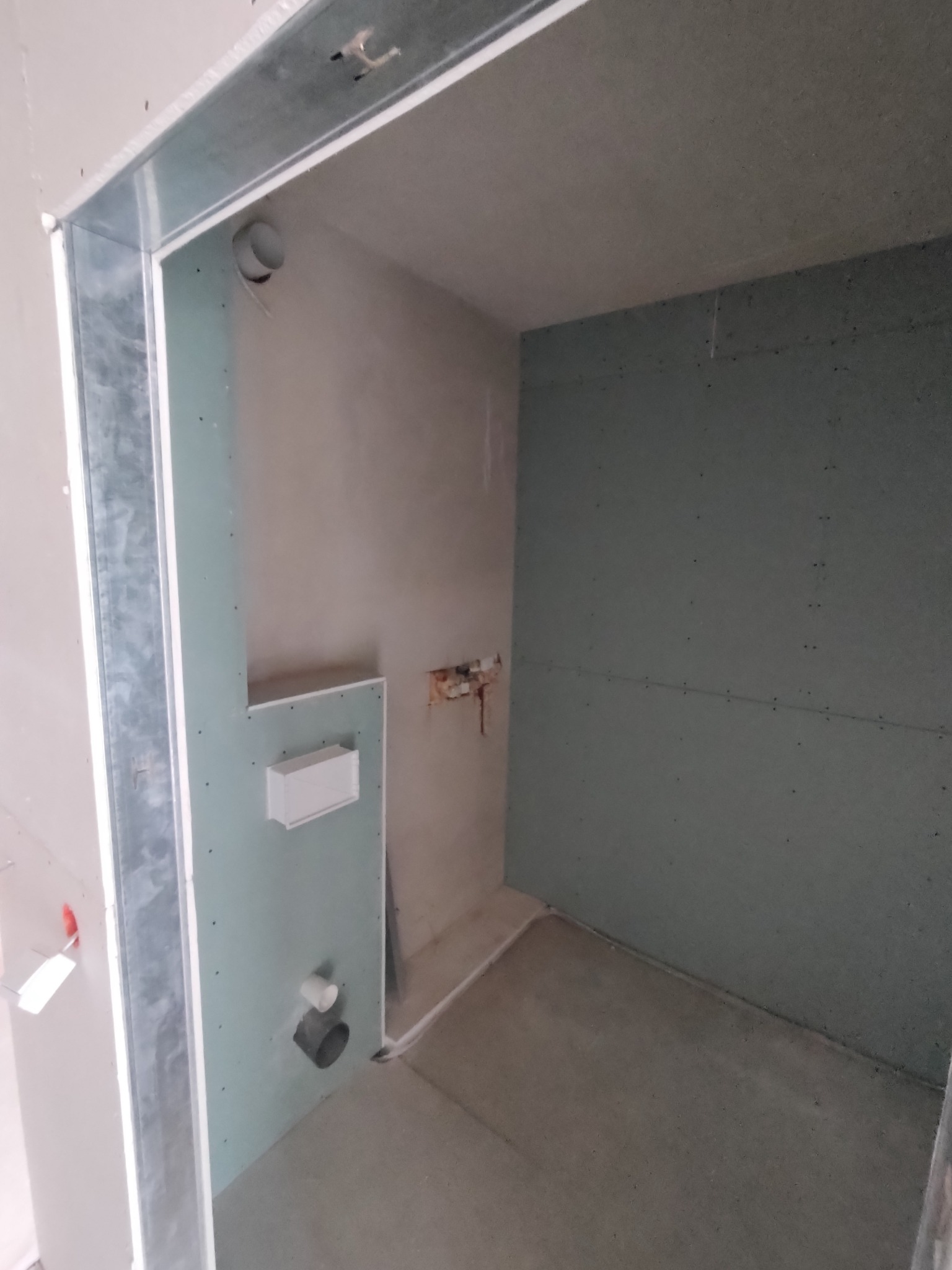 Surowa łazienka w trakcie remontu: płyty karton-gips, metalowy stelaż, instalacje hydrauliczne, przygotowana do dalszych prac wykończeniowych.