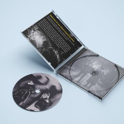 Artur Małowiejski - Usługi Graficzne - Otwarty jewel case CD z okładką i płytą z czarno-białą grafiką na jasnoniebieskim tle. Widoczny tekst powitalny na okładce i detale graficzne na płycie.