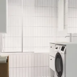 Nowoczesna łazienka w Szczecinie z białą pralką zabudowaną w szafce, białe płytki na ścianach i wzorzysta podłoga w odcieniach błękitu i szarości.