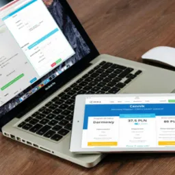 Ekran laptopa i tabletu prezentujące interfejs programu do fakturowania i księgowości online, z widocznym cennikiem i formularzem faktury. Obok myszka.