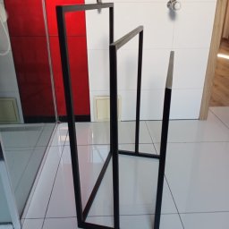 Marek Paruzel - Czarny, metalowy stojak na ręczniki w łazience z białą glazurą i grzejnikiem. Minimalistyczny design, spawana konstrukcja, nowoczesne wykończenie.