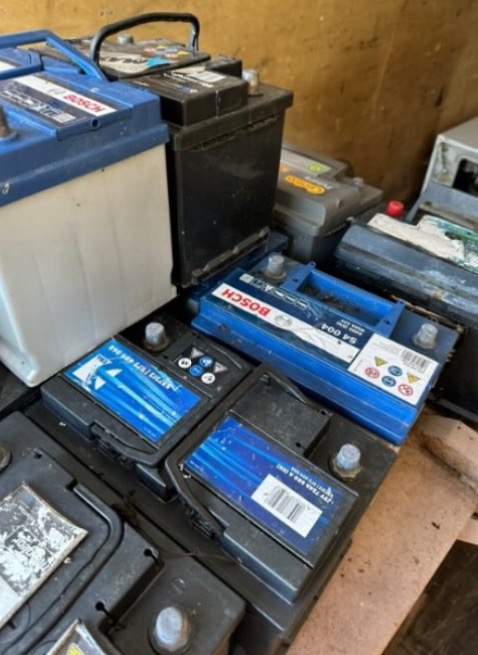 Stare, zużyte akumulatory samochodowe różnych marek, w tym Bosch, przygotowane do utylizacji. Widoczne ślady użytkowania i zabrudzenia.