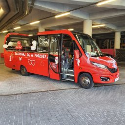 JACEK LEGENDZIEWICZ JORDAN GROUP - Czerwony, udekorowany bus z otwartymi drzwiami, z napisem 'Zakochaj się w podróży...' i balonami. Dekoracja ślubna, przewóz osób.