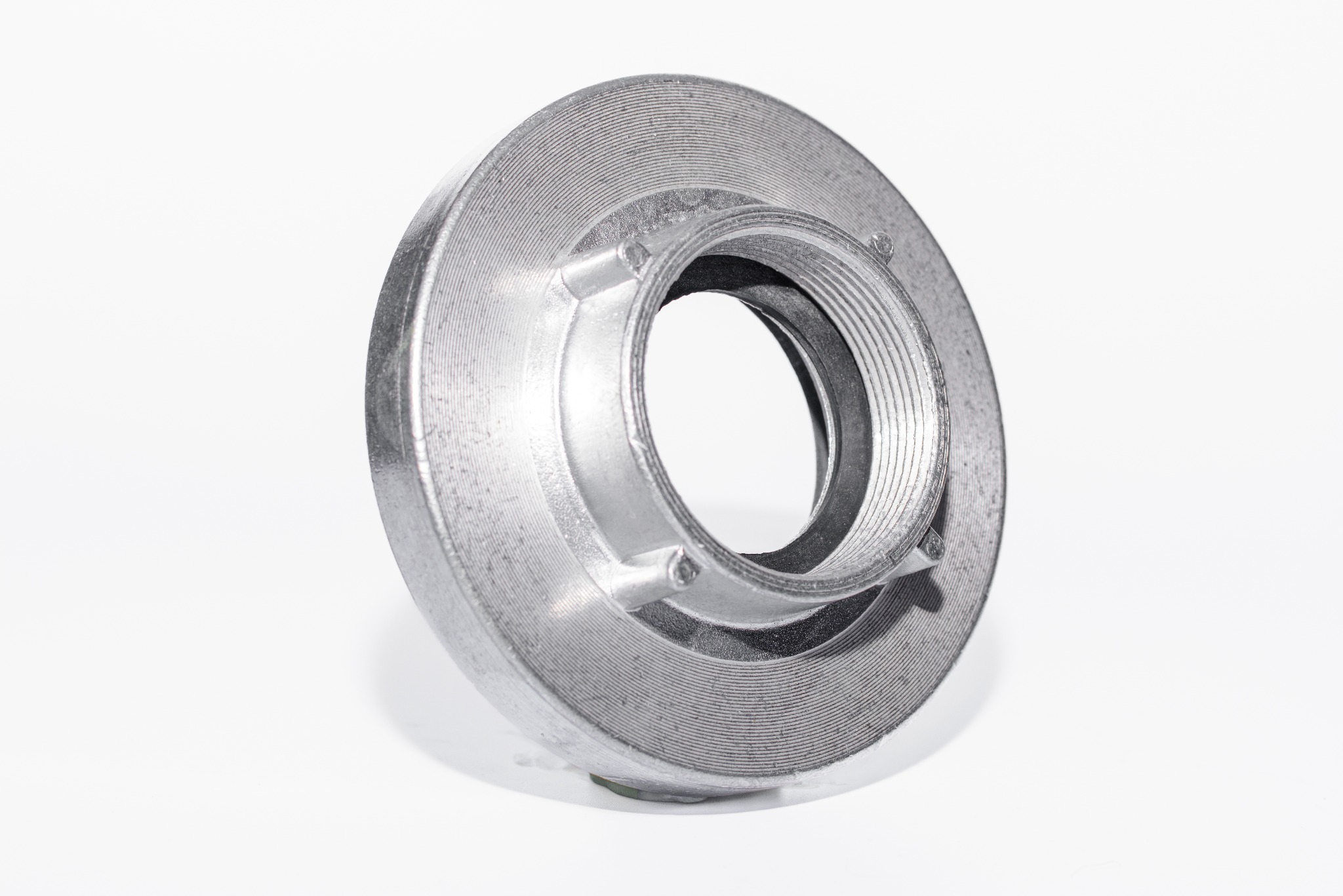 Precyzyjnie wykonany, metalowy element z gwintem wewnętrznym i zewnętrznym, widoczne ślady obróbki skrawaniem na jasnym tle.