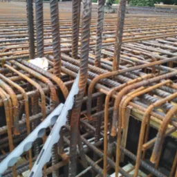 Zbrojenie stropu z widocznymi prętami żebrowanymi i elementami dystansowymi. Przekrój zbrojenia z bliska, widoczne detale konstrukcyjne i etap prac budowlanych.