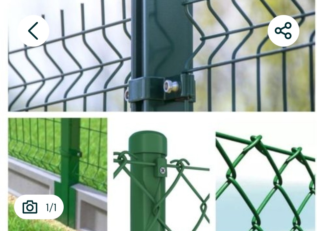 Zielone ogrodzenie panelowe z bliska, mocowane do słupka za pomocą metalowych obejm. Widoczne fragmenty różnych typów ogrodzeń.