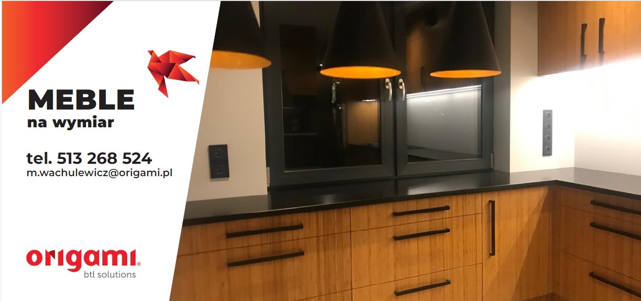 Nowoczesna kuchnia z drewnianymi frontami, czarnym blatem i oknem. Nad blatem wiszą trzy czarne lampy z pomarańczowym wnętrzem. Widoczna część logo firmy po lewej.